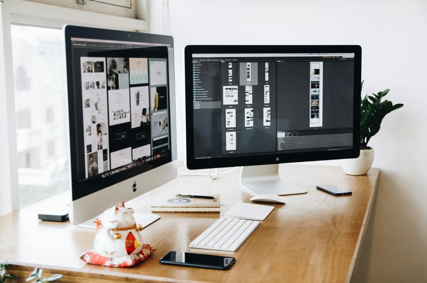 Website design mockups displayed across two desktop monitors